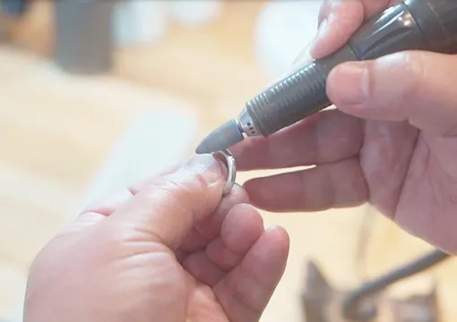 職人が指輪を仕上げている写真