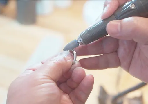 指輪職人が結婚指輪を仕上げている写真